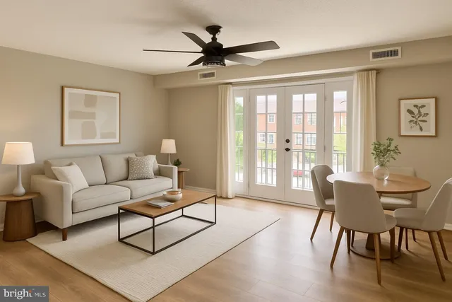 a living room with furniture a ceiling fan and a large window