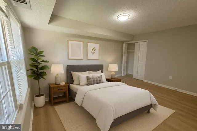 a bedroom with a bed and a potted plant