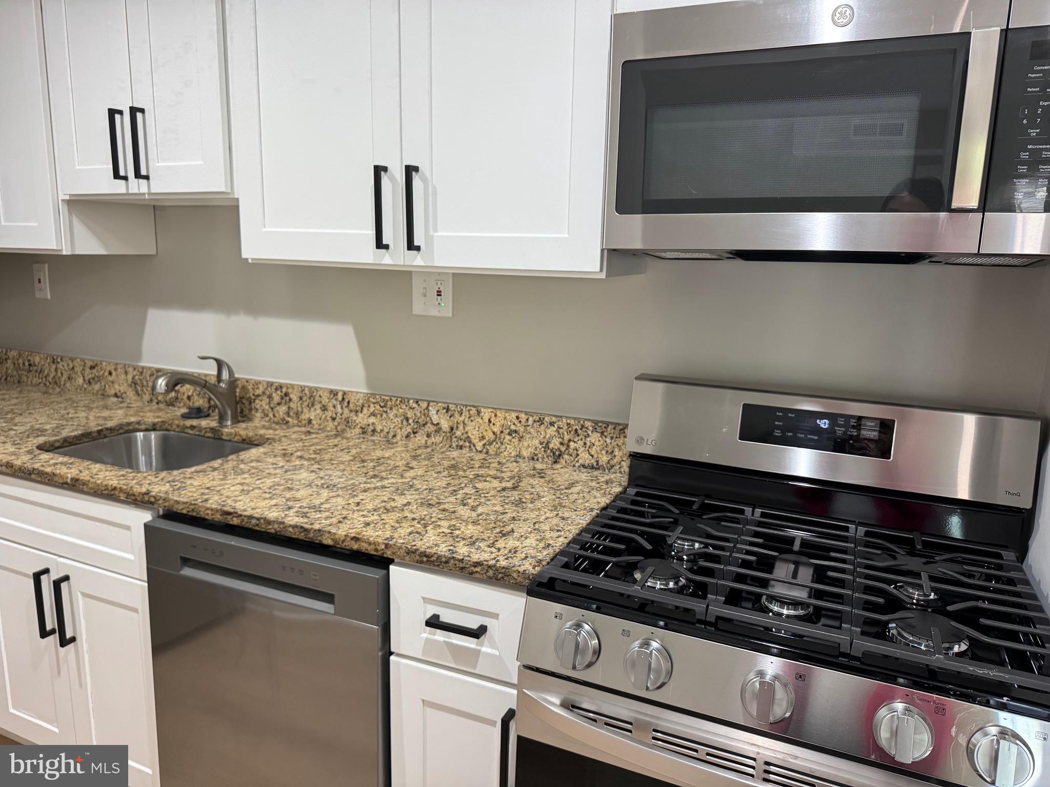 3817 Swann Road, Unit 302 Suitland, MD 20746 - Photo 12 of 26 a kitchen with granite countertop a sink and a stove