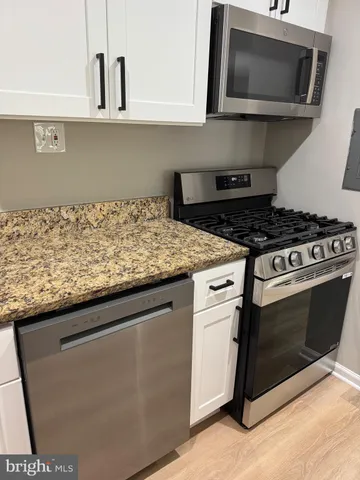 a kitchen with stainless steel appliances granite countertop a sink and a stove