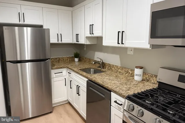 a kitchen with stainless steel appliances granite countertop a refrigerator sink and stove