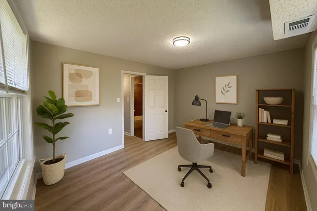 a view of a workspace with furniture and a window