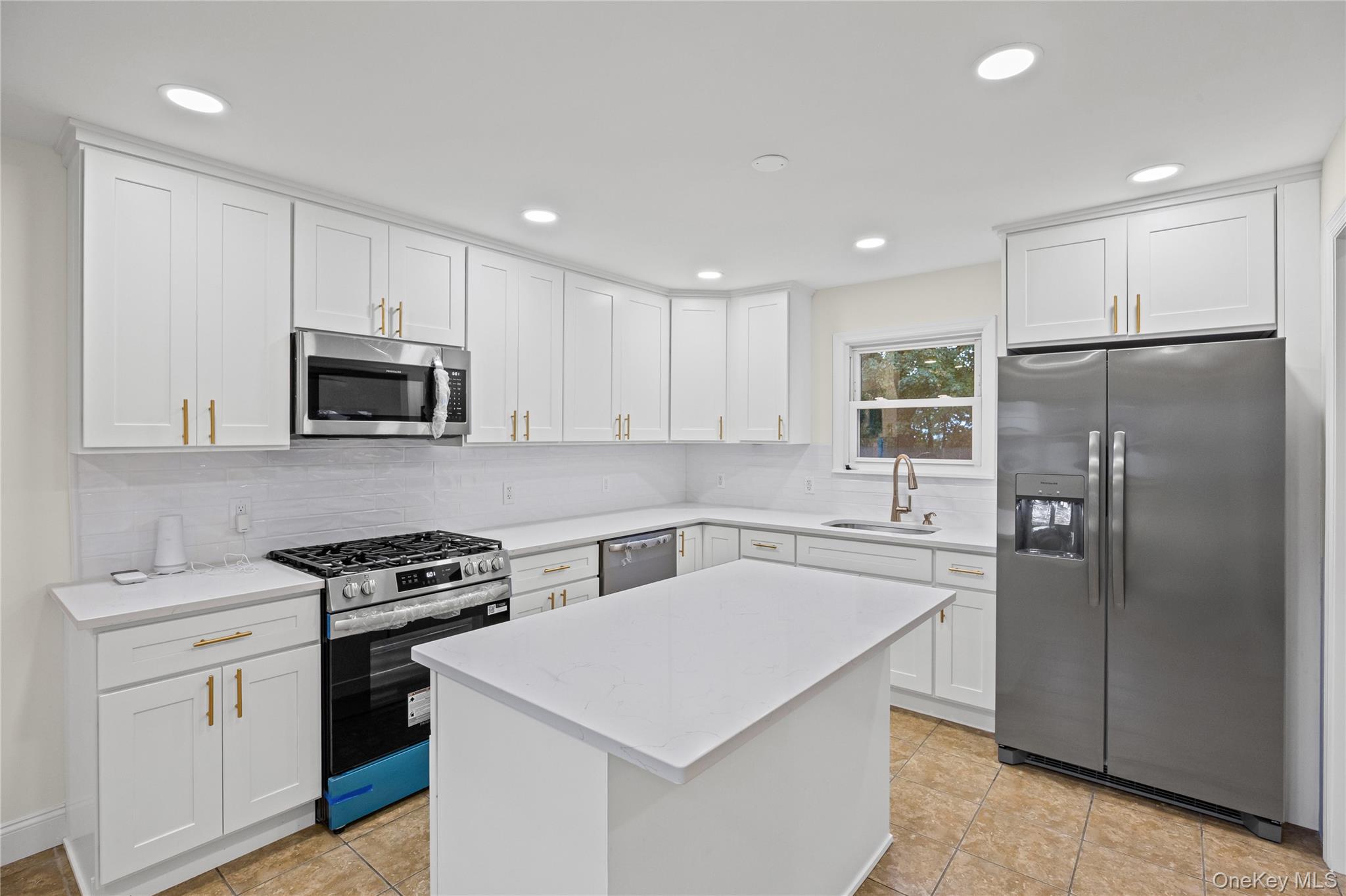 31 Colony Road Port Jefferson Station, NY 11776 - Photo 15 of 32 a kitchen with stainless steel appliances a refrigerator stove microwave and sink