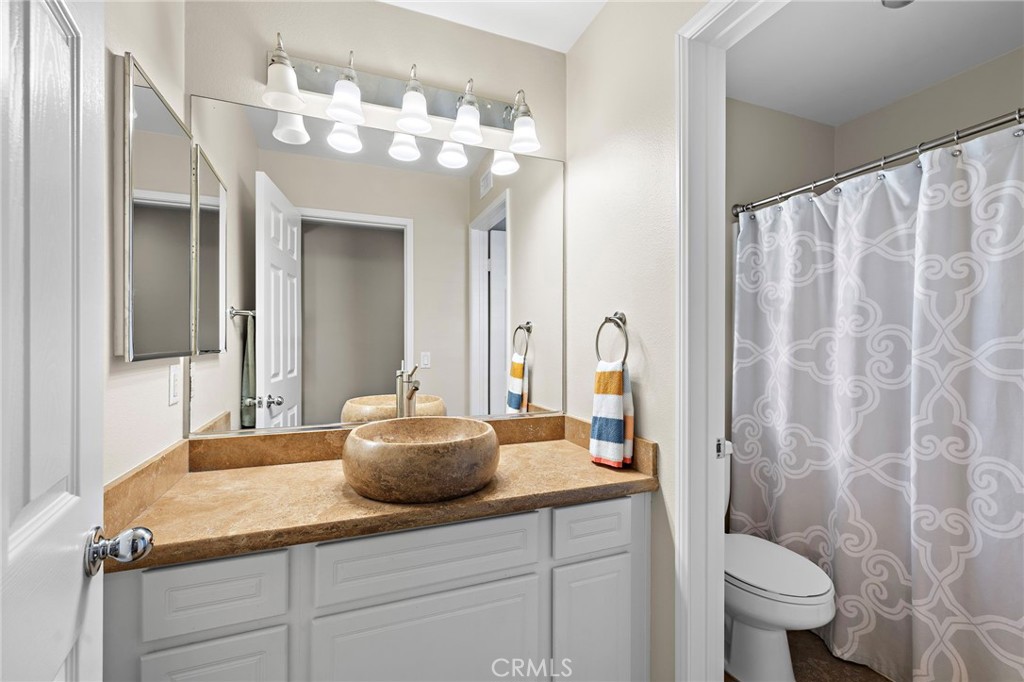 71 Sklar Street Ladera Ranch, CA 92694 - Photo 27 of 55 a bathroom with a granite countertop sink a toilet and a mirror