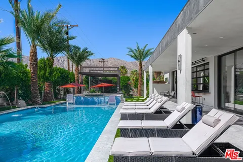 a view of a patio with table and chairs potted plants and palm tree