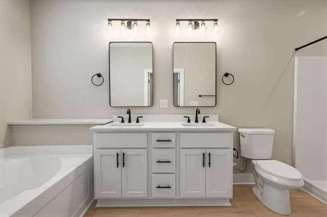 a bathroom with double vanity sink and a bathtub