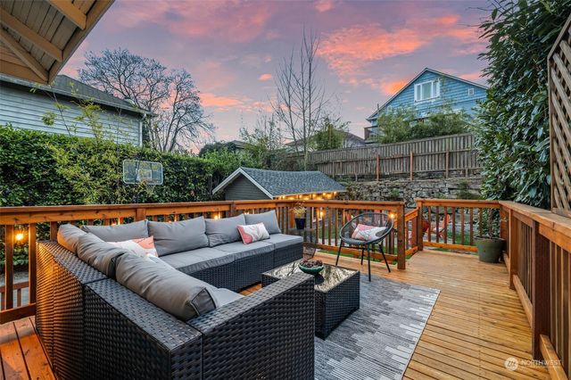 a view of a house with wooden deck and furniture