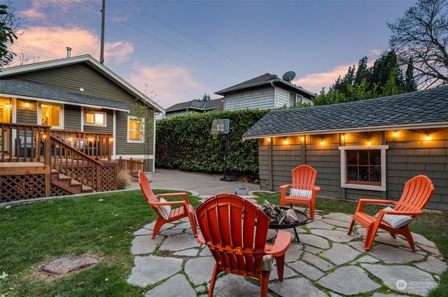 a view of a chair and table in backyard of the house