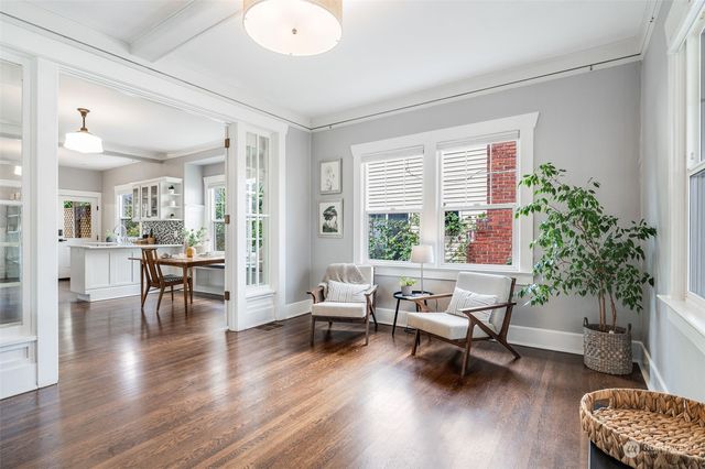 a living room with furniture and a dining table with wooden floor