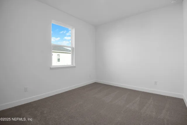 a large white kitchen with kitchen island sink refrigerator and white cabinets