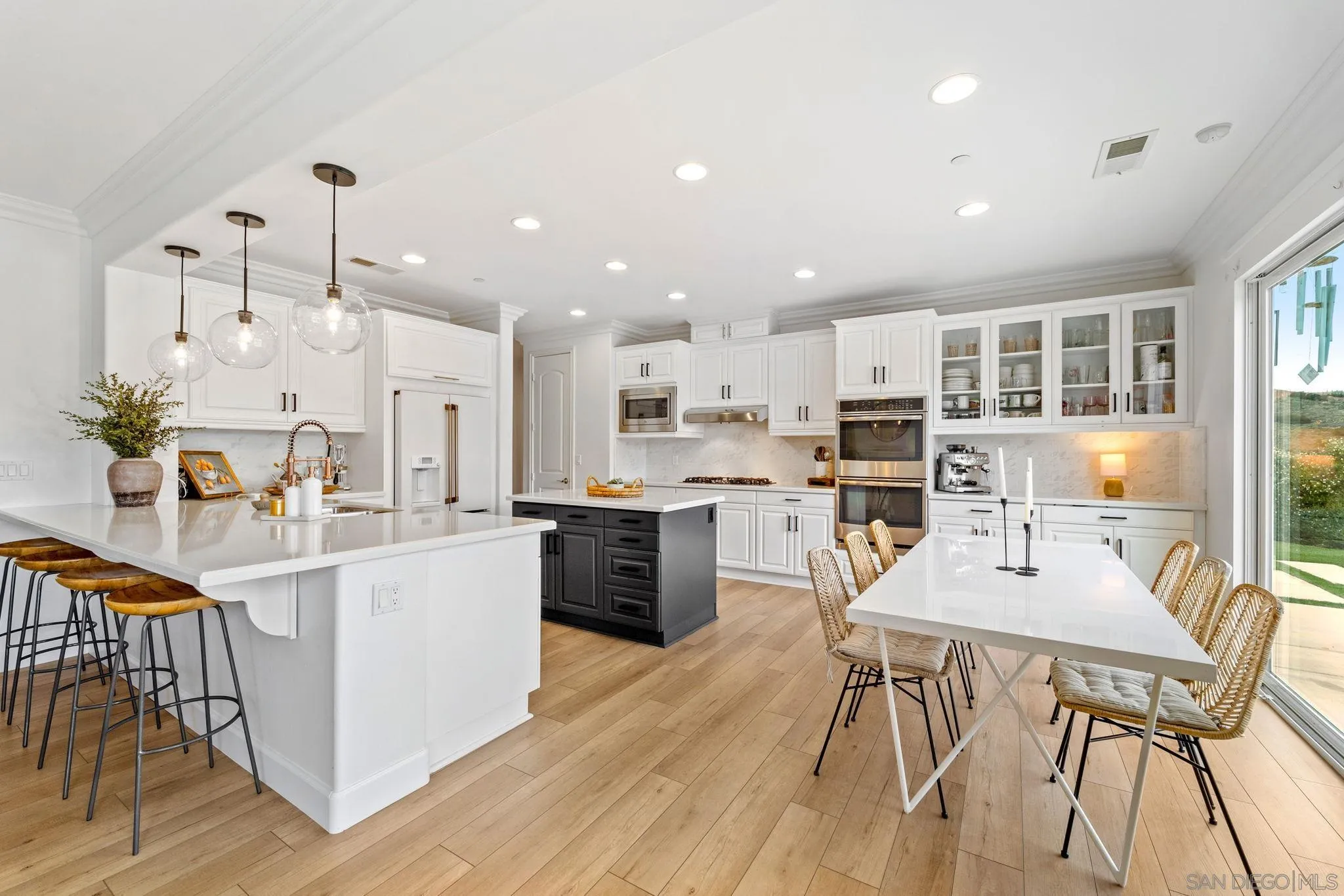 2836 Mesa Grove Road Fallbrook, CA 92028 - Photo 11 of 46 a kitchen with stainless steel appliances kitchen island wooden floors and white cabinets