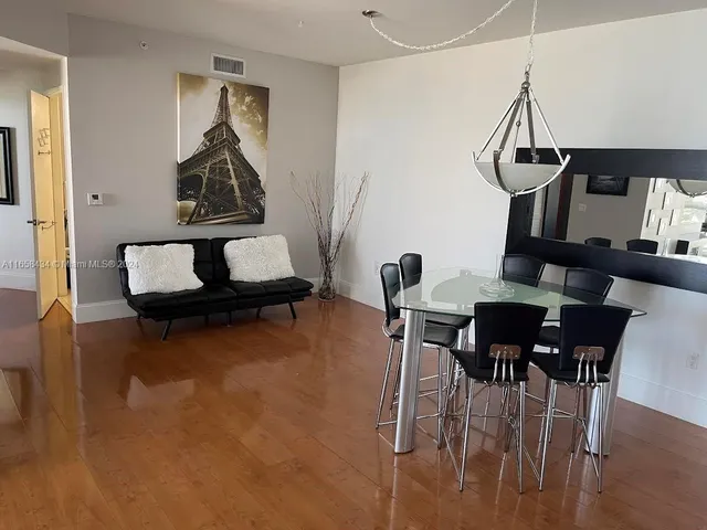 a white toilet sitting next to a bathroom sink and a mirror