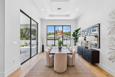 a living room with furniture large windows and wooden floor