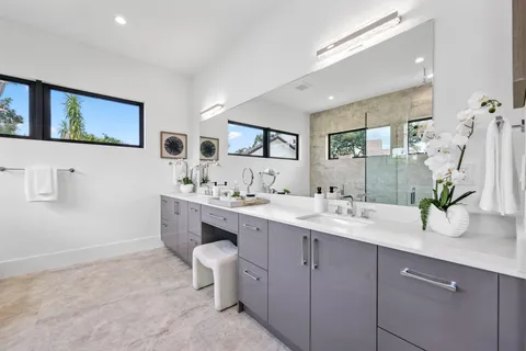 a bathroom with a granite countertop sink mirror and toilet