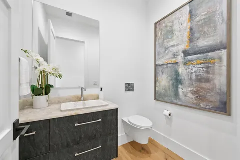 a bathroom with a sink vanity granite and toilet