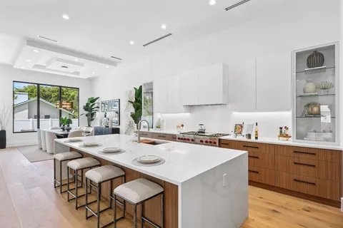 a kitchen with stainless steel appliances a table and chairs in it