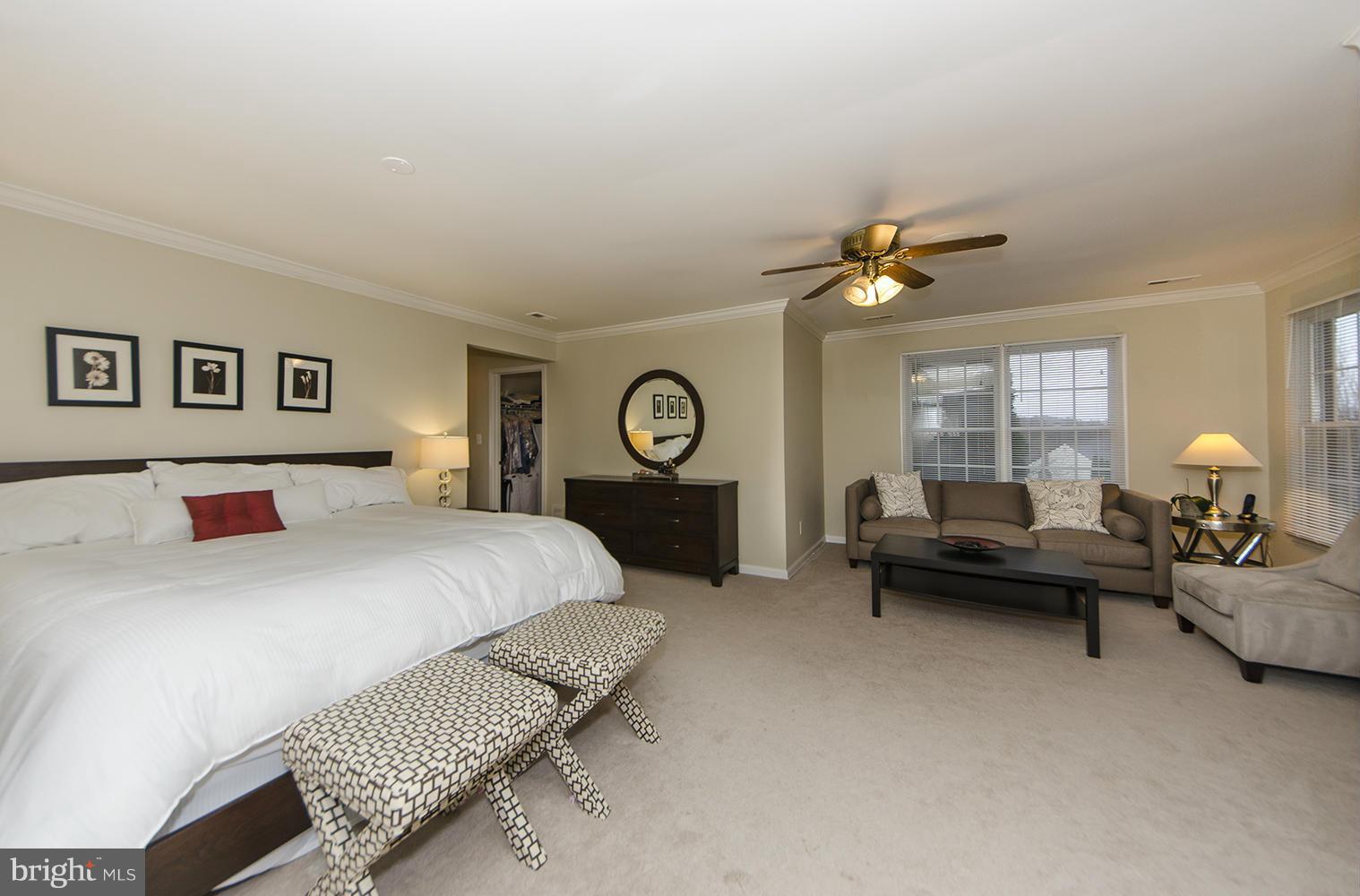 10871 Hunter Gate Way Reston, VA 20194 - Photo 13 of 30 a spacious bedroom with a bed and a chandelier