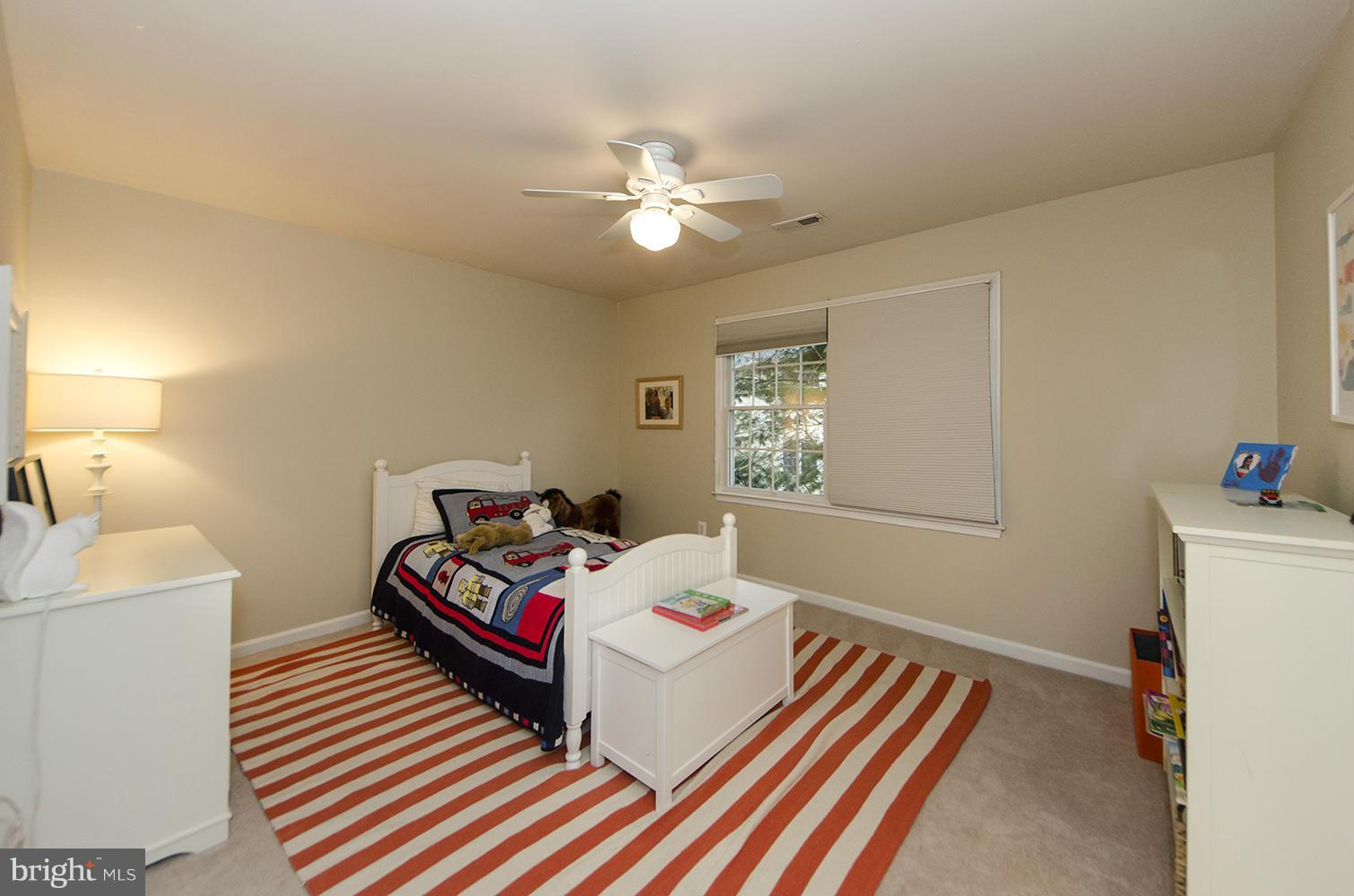 10871 Hunter Gate Way Reston, VA 20194 - Photo 17 of 30 a bedroom with a bed and a chandelier