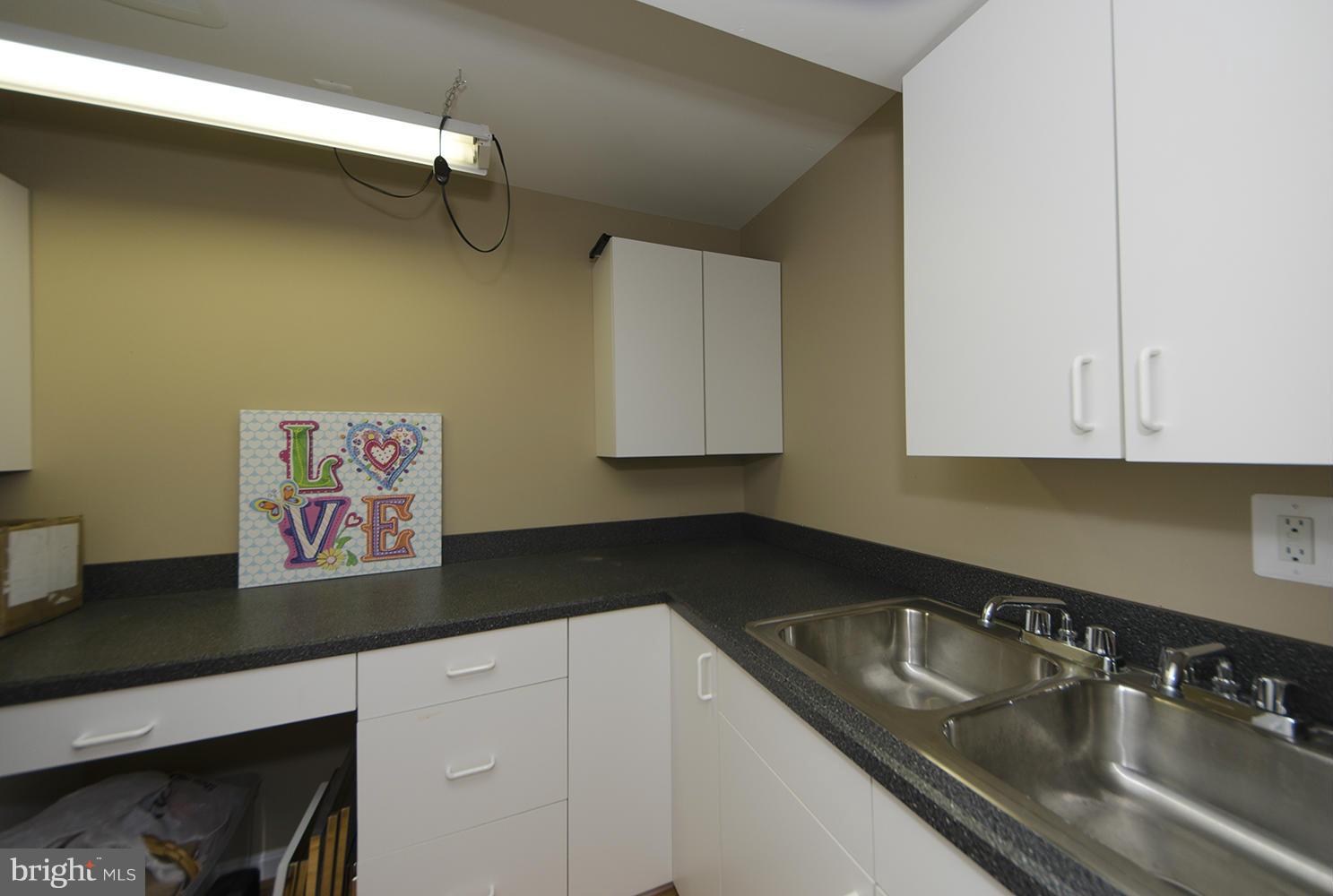 10871 Hunter Gate Way Reston, VA 20194 - Photo 27 of 30 a kitchen with stainless steel appliances granite countertop a sink dishwasher and cabinets with wooden floor