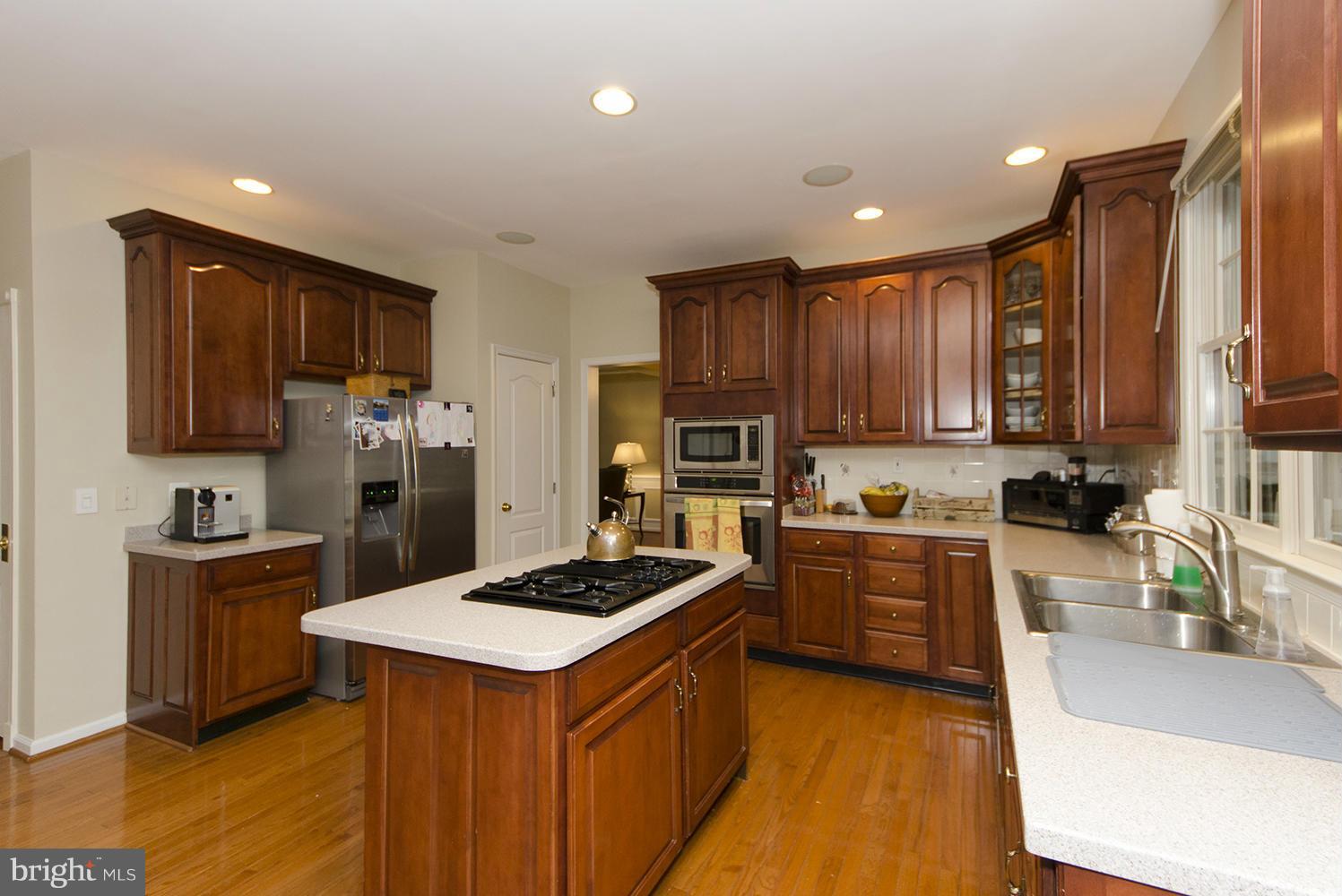 10871 Hunter Gate Way Reston, VA 20194 - Photo 9 of 30 a kitchen with stainless steel appliances granite countertop a sink stove refrigerator and cabinets