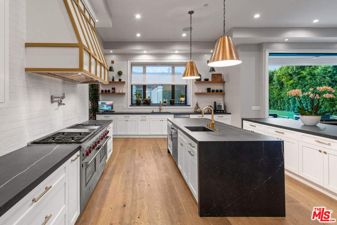 4421 Haskell Avenue Encino, CA 91436 - Photo 16 of 40 a kitchen with stainless steel appliances granite countertop a sink a stove and a refrigerator