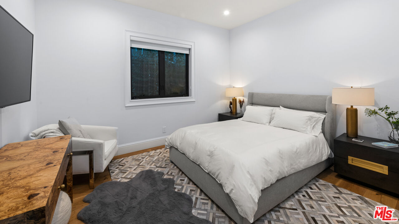 4421 Haskell Avenue Encino, CA 91436 - Photo 35 of 40 a bedroom with a bed and a lamp on dresser