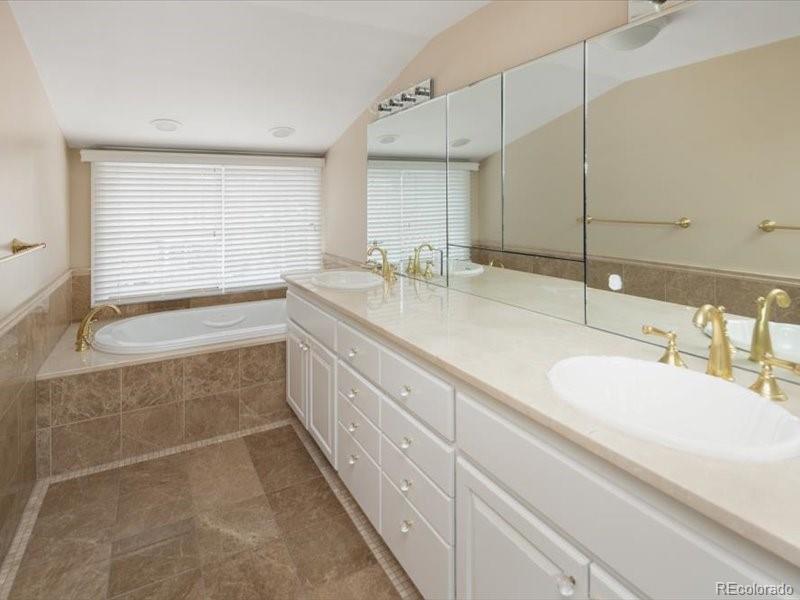 199 Lafayette Street Denver, CO 80218 - Photo 23 of 49 a bathroom with a double vanity sink a mirror and a bathtub