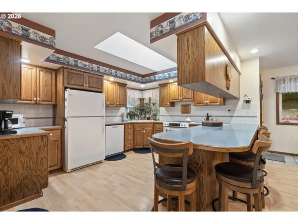 a kitchen with stainless steel appliances kitchen island granite countertop a refrigerator a stove a sink dishwasher with a dining table and chairs