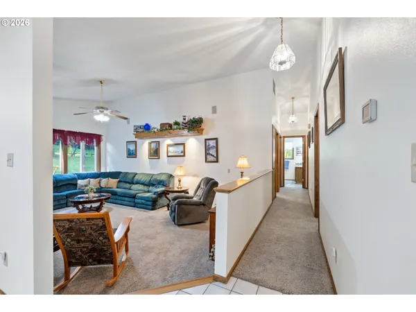 a living room with furniture kitchen view and a window