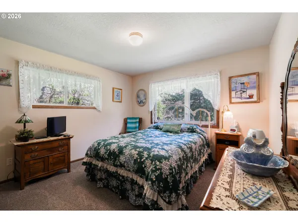 a bedroom with a bed and large windows