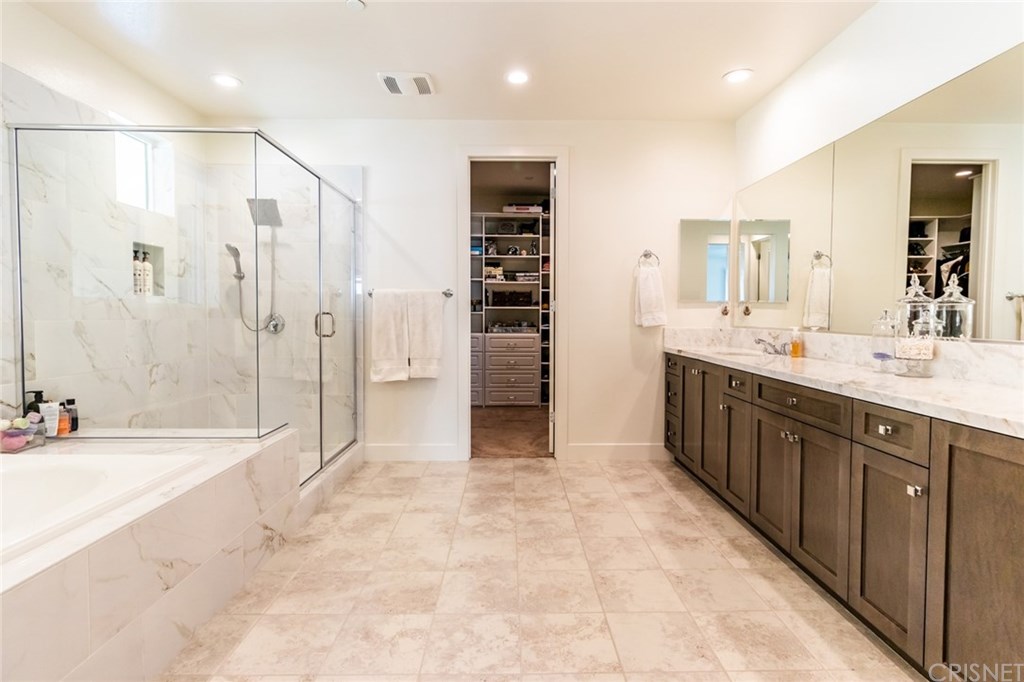 19047 Bension Drive Saugus, CA 91350 - Photo 28 of 72 Primary suite bathroom with marble counters, shower and bathtub siding. Also a view of custom closet and large countertop space.