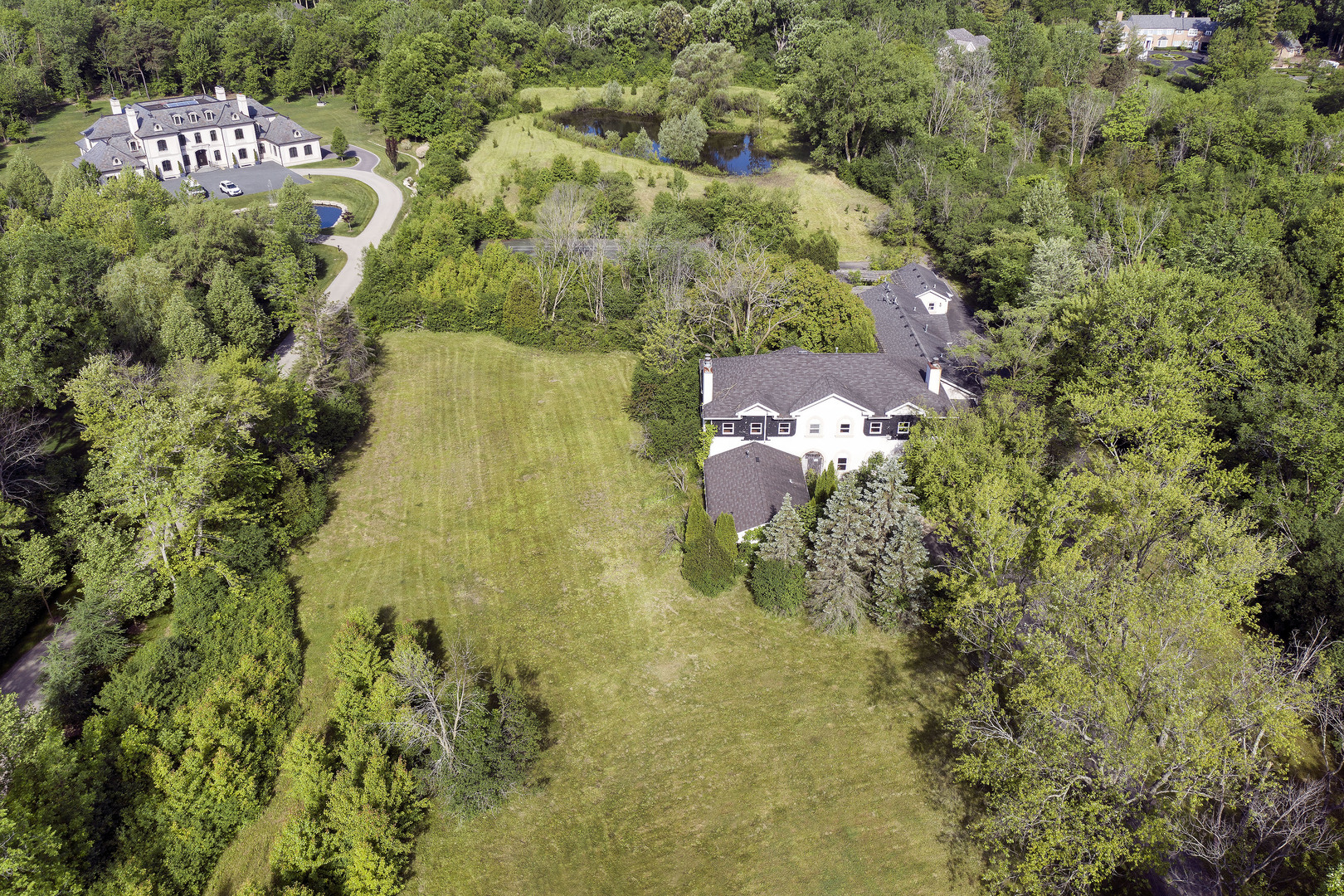 a aerial view of residential house with outdoor space and trees all around