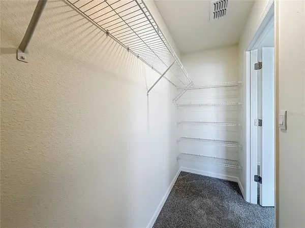 a view of a big room with wooden floor closet ceiling fan and windows