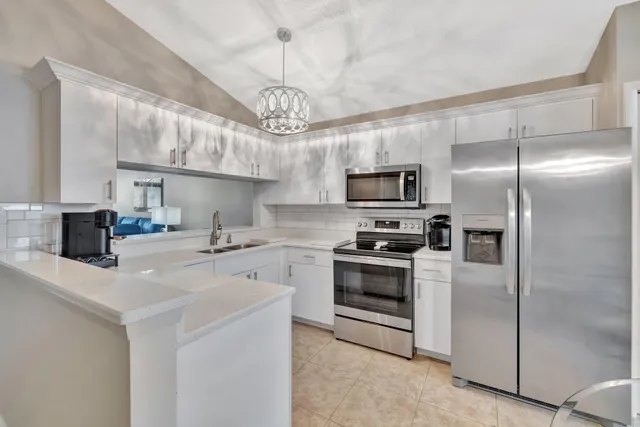 a kitchen with stainless steel appliances granite countertop a refrigerator a stove a sink dishwasher a refrigerator white cabinets and wooden floor