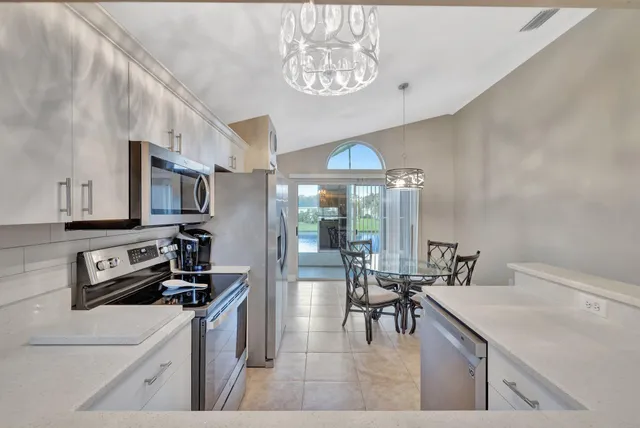 a kitchen with stainless steel appliances a sink a stove and cabinets