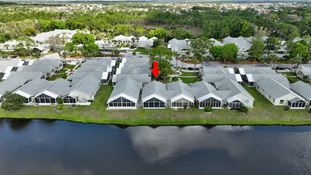 an aerial view of a house with a garden and lake view