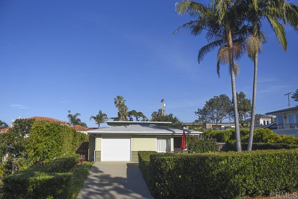 a view of a house with a yard and potted plants