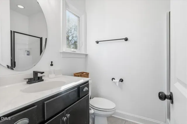 a kitchen with stainless steel appliances granite countertop a sink a stove a refrigerator and white cabinets with wooden floor