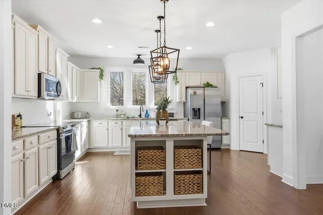 a kitchen with granite countertop a sink stove and cabinets