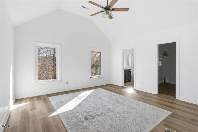 a backyard of a house with lots of plants and a large tree