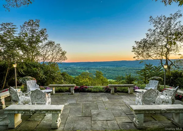 a view of a patio with couches table and chairs and potted plants