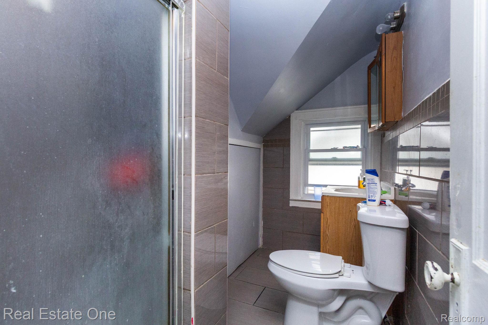 5485 Springwells Street Detroit, MI 48210 - Photo 30 of 47 Bathroom featuring a frosted glass shower enclosure, tiled walls, and a window for natural light