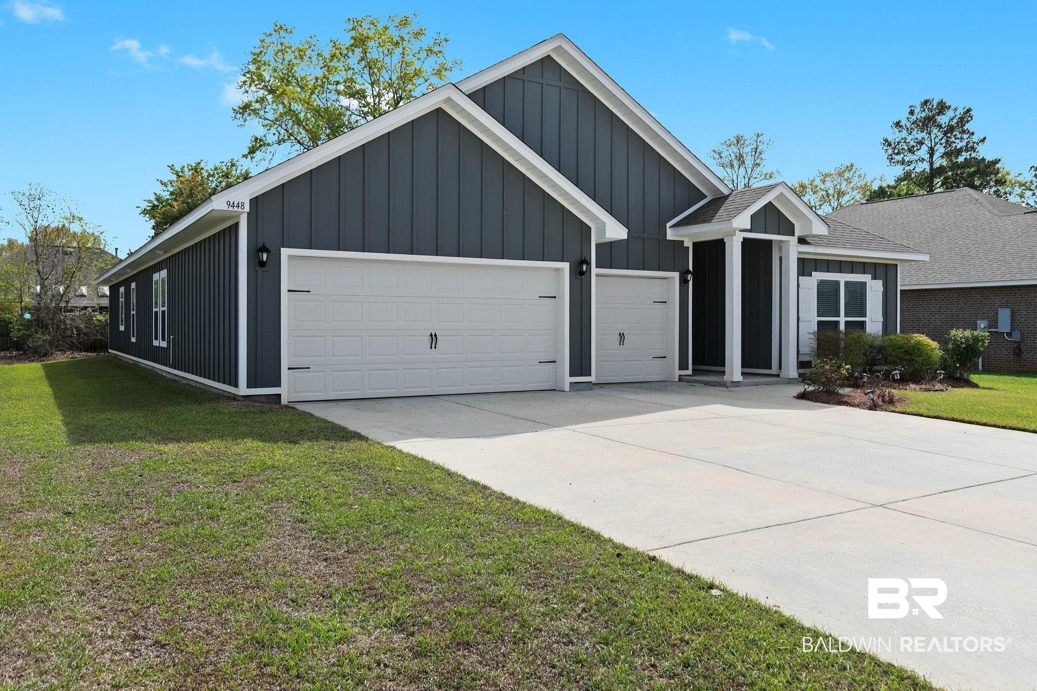 9448 Amethyst Drive Daphne, AL 36526 - Photo 6 of 61 View of front of property featuring board and batten siding, a front lawn, driveway, and an attached garage