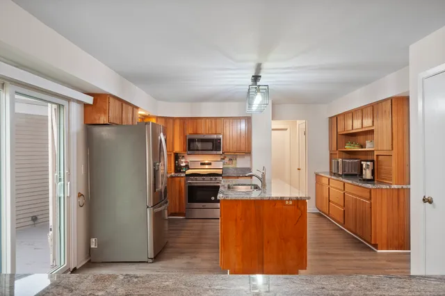 a kitchen with stainless steel appliances granite countertop a refrigerator and a stove top oven