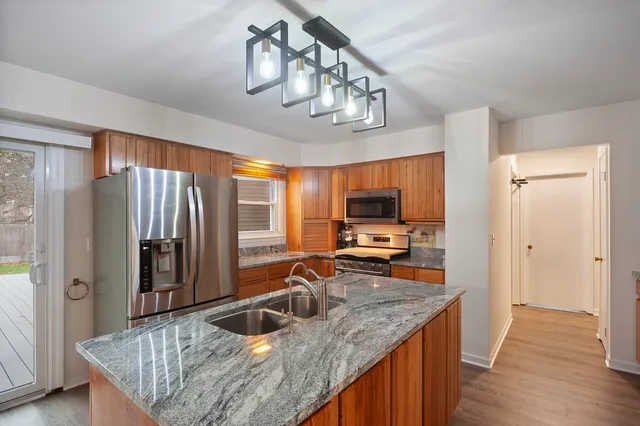 a kitchen with stainless steel appliances granite countertop a sink refrigerator and cabinets