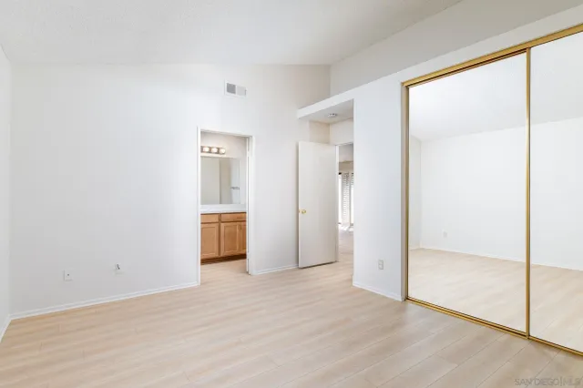 a view of a big room with wooden floor and windows
