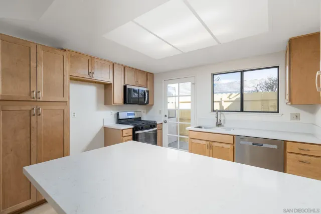 a kitchen with a refrigerator a stove a sink dishwasher and wooden cabinets