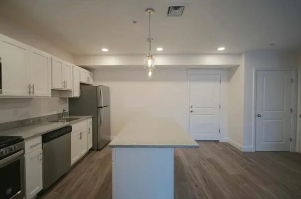 a kitchen with stainless steel appliances a stove microwave and sink