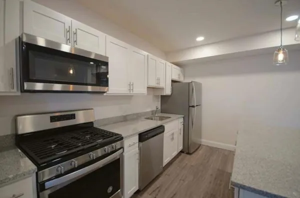 an empty room with wooden floor and a fireplace