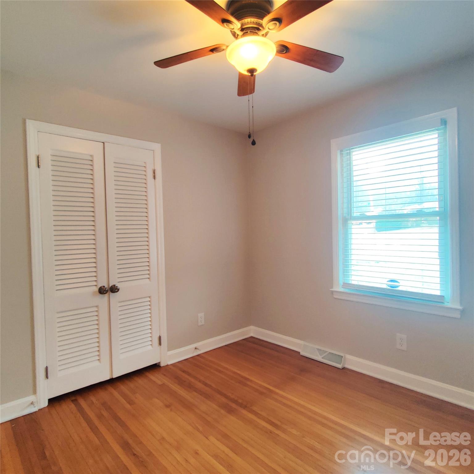 4100 Broadview Drive Charlotte, NC 28217 - Photo 17 of 24 an empty room with wooden floor fan and windows